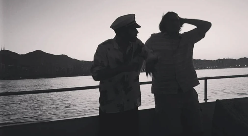 Black and white silhouettes on a boat at dusk