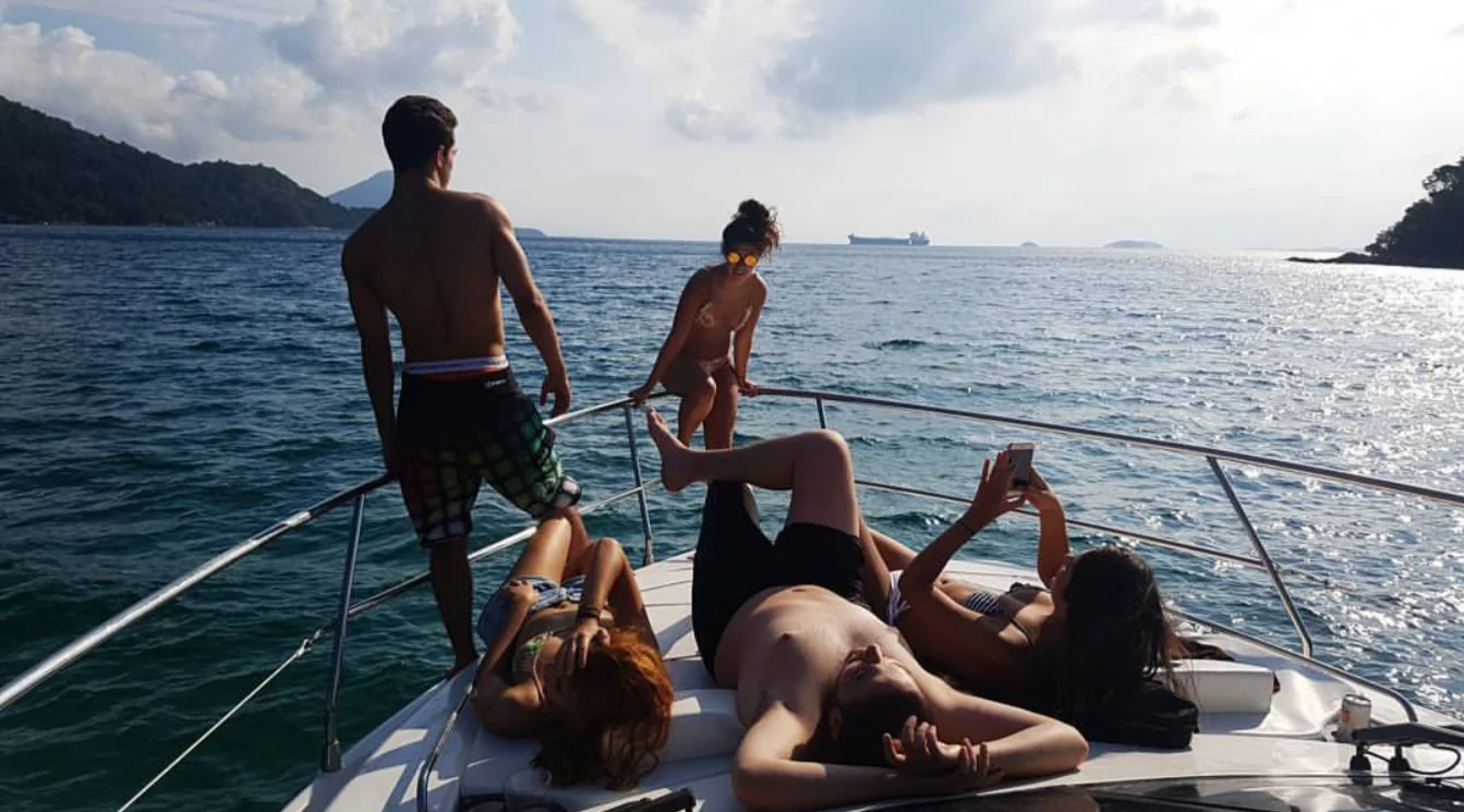 Bow of a boat with people relaxing and Raphael standing over the open sea
