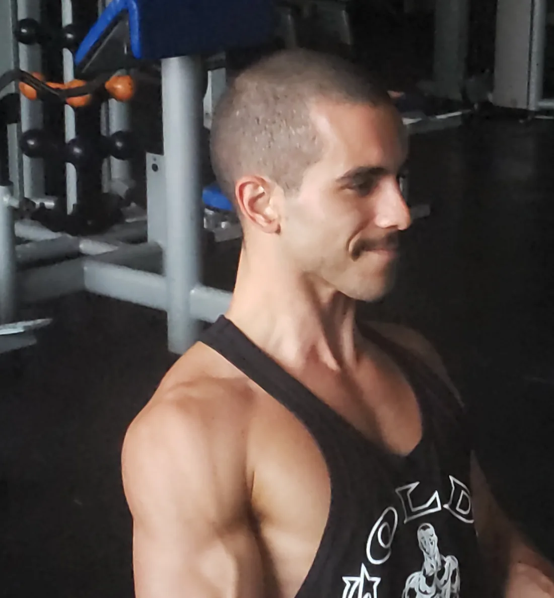 Raphael in side profile at the gym, calm and focused