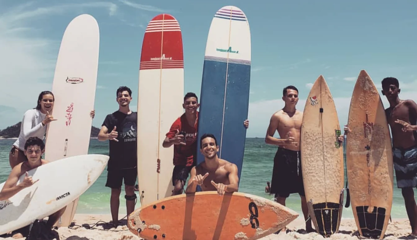 Friends standing on the beach with many surfboards