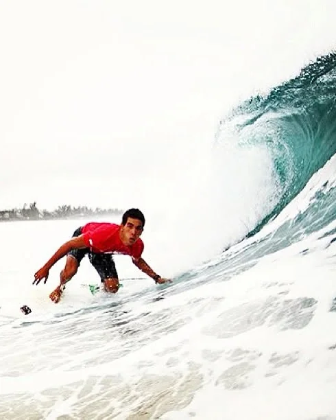 Raphael crouching under a barreling wave